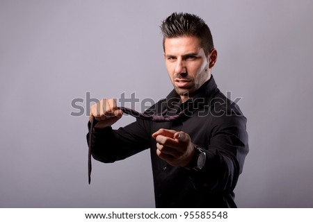 man pulling his tie looking aggressive