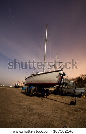 sailing boat at a boat yard on the wirral at night under the moon and stars