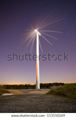 wind turbine at night with stars showing movement
