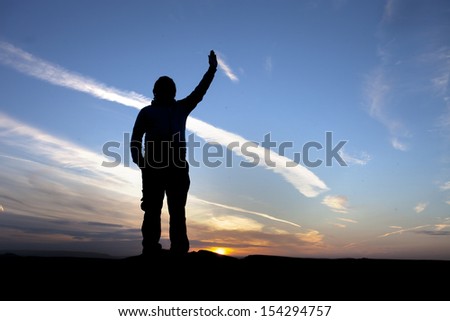 silhouette of man holding up his hand