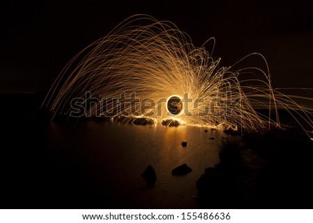 spinning fire and reflection off water