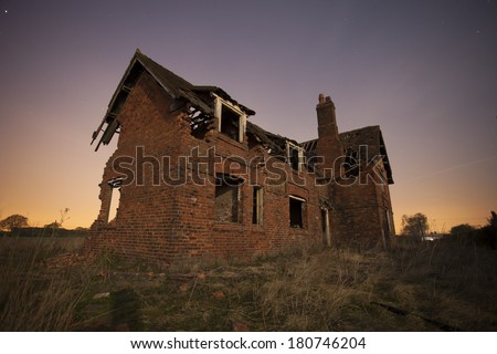 old abandoned house at night with star trails