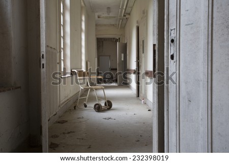 wheel chair by windows in old abandoned hospital