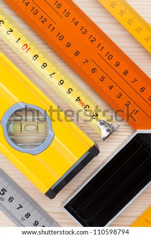 Assorted measurement tools, arranged on wooden surface, as an abstract background