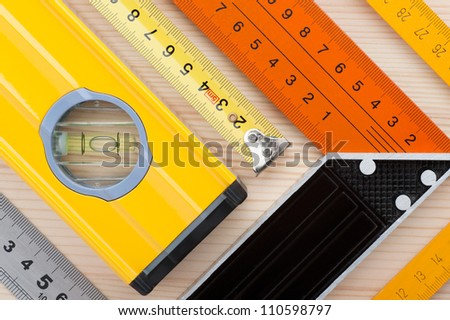 Assorted measurement tools, arranged on wooden surface, as an abstract background