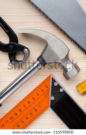 Assorted construction and measurement tools arranged on a wooden surface. Construction, repair or home improvement background.