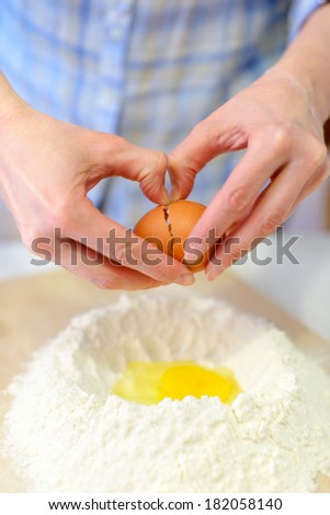 Cooking: woman making dough, adding eggs to flour