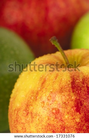 Four wet apples - red, yellow and green, vertical crop
