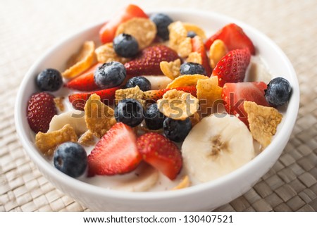 healthy breakfast, corn flakes with strawberry, blueberry, banana and milk