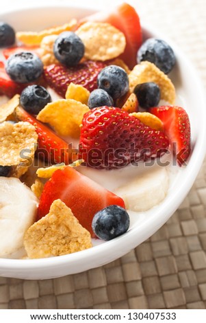 healthy breakfast, corn flakes with strawberry, blueberry, banana and milk