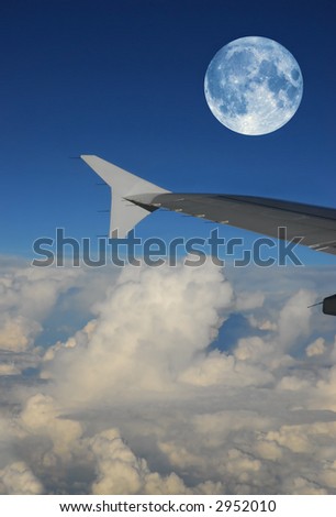 airplane wing during a full moon flight