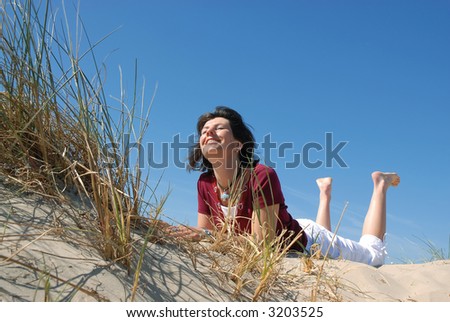 girl laughing and day dreaming at the beach