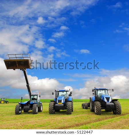 composition of farming machinery on farmland with blue sky background