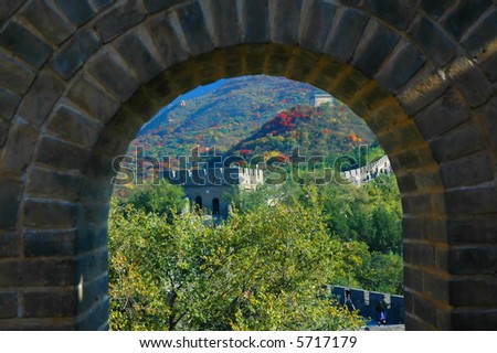 chinese wall in autumn, seen through a brick stone window