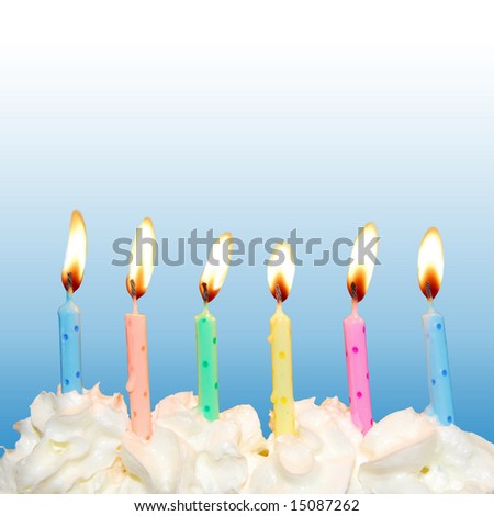 Colorful birthday candles on cake with whipped cream and blue square background