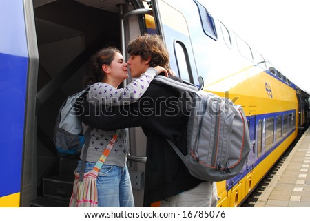 Cute couple in their twenties hugging and kissing each other goodbye at train station in Holland