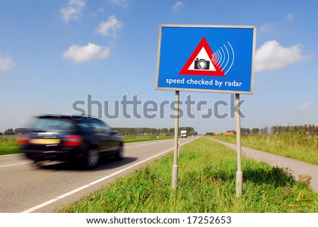 Speed checked by radar roadsign in rural landscape and speeding car with motion blur