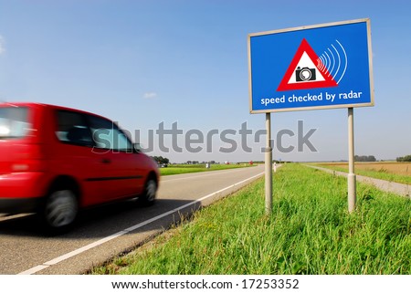 Speed checked by radar roadsign in rural landscape and speeding red car with motion blur
