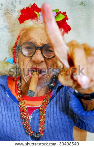HAVANA – CIRCA DECEMBER 2008: An eccentric old Cuban lady smokes cigar and points finger circa December 2008 in Havana, Cuba.