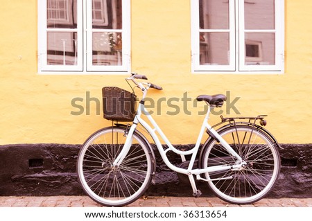 Vintage bike with basket against wall in Denmark in sepia tone