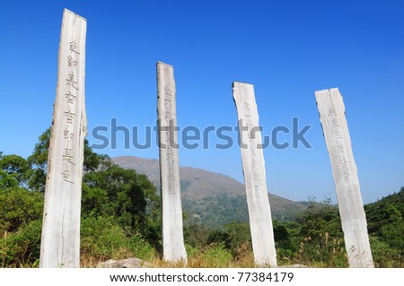 Wisdom Path of Heart Sutra - Chinese prayer on trunks under blue sky from Lantau Island country park, Hong Kong, China