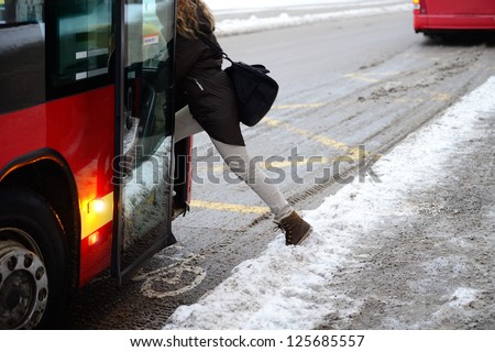 Woman entering bus in winter