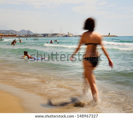 Woman walking on the beach (effect caused by long time exposure)