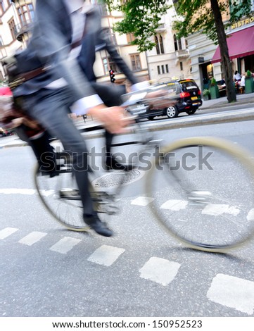 Motion Blurred Man In Suit On Bike