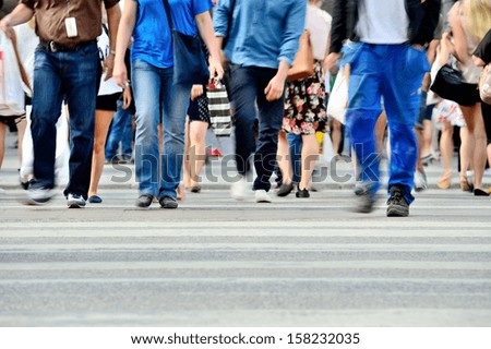 Motion blurred pedestrians crossing sunlit street Motion blurred pedestrians crossing sunlit street