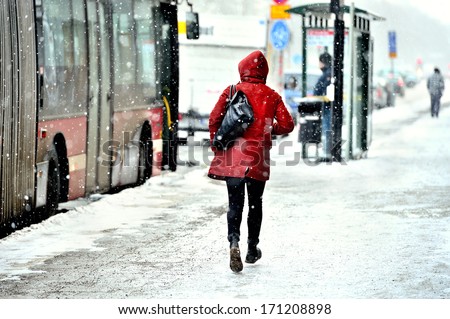 Commuter running to bus in snowstorm