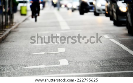 Gloomy road with arrows, bicylist distant