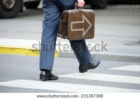 Bag with arrow. Suit (man) in silhouette walking on the street with bag.