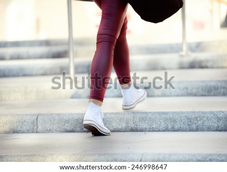 Young adult woman walking up the stairs