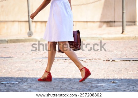 Woman walking home after work with portfolio bag