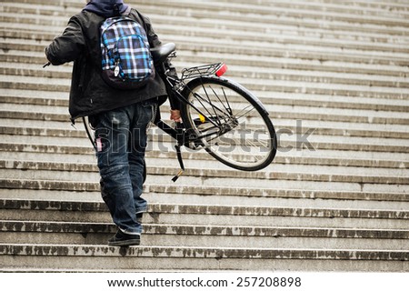 Man carrying bike up the stairs
