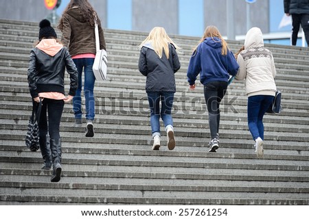 Young crowd walking up the stairs in the rain