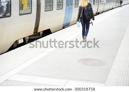Woman walking and stationary commuter train