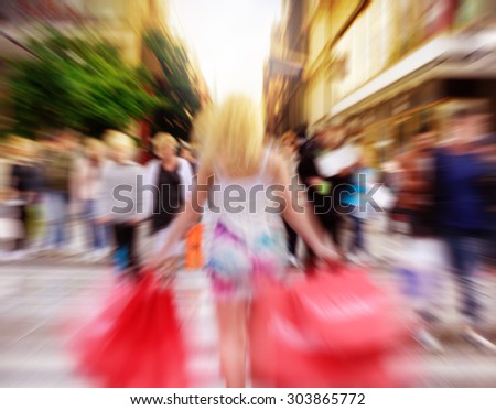 Motion and zoom blurred shopping woman