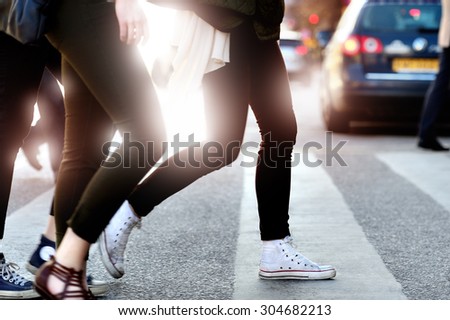Pedestrians crossing street against bright light