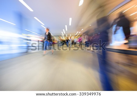 Zoom and motion blurred crowd walking in city