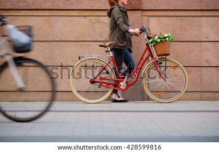 Woman walking with red bike