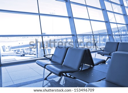 modern airport terminal waiting room with window outside scene of flight departure