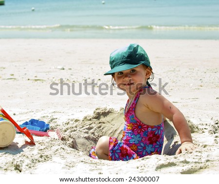 Girl plays on the sand with the toys