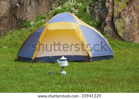 Camp kettle on gas stove with tent in background