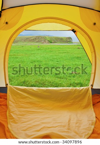 Kind from tent on lawn with green grass