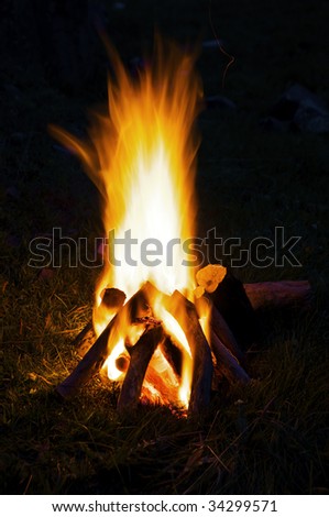 A small campfire built outdoors for people to sit around