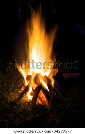 A small campfire built outdoors for people to sit around