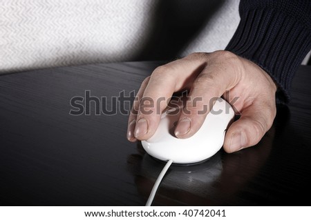 The man\'s hand works with the white mouse