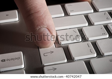 The man's hand works with the keyboard