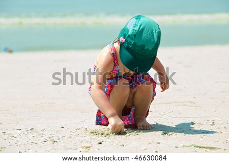 Girl plays on the sand with the toys. Thailand